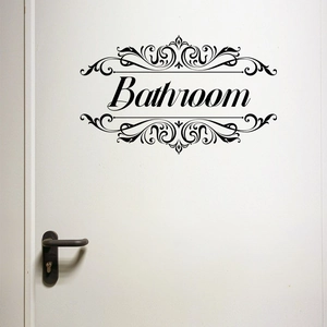Close-up of black PVC bathroom door sticker with elegant vine patterns on a white door