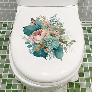 Detail of floral butterfly decals on a white toilet lid with green mosaic tiles background