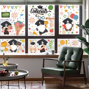 Graduation window clings featuring cute gnomes, owls, and balloons on a glass surface