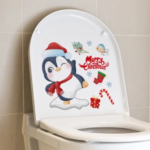 Detail of Christmas snowman sticker with cartoon penguin on a white toilet lid cover