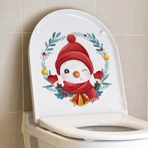 Detail view of snowman Christmas sticker with red hat applied on a white toilet lid