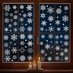 Sparkling silver snowflake window stickers set on glass with warm candles and winter vibe