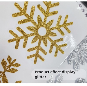 Close-up macro detail showing the gold glitter texture of a snowflake window sticker