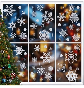 Close-up of white glitter snowflake window decals on glass with festive Christmas lights
