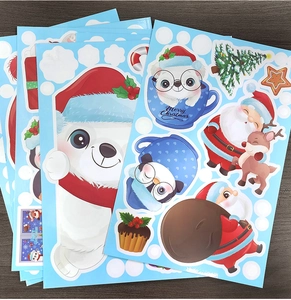 Close-up of colorful Christmas window stickers with polar bears and Santa on wooden desk