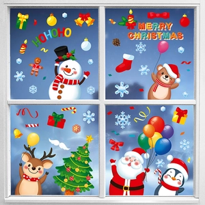 Détails des stickers de Noël avec Père Noël et renne sur une vitre d'hiver enneigée