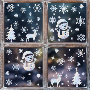 Close-up of holographic Christmas window stickers with elk and snowflake rainbow reflection