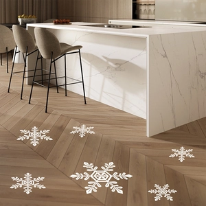 Close-up of white snowflake window clings on marble and herringbone wood floors
