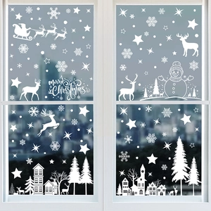 White Christmas window stickers featuring Santa, reindeer, and snowflakes on glass surface