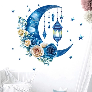 Détail de stickers muraux lune bleue et étoiles avec fleurs dans une chambre d'enfant