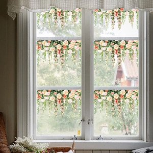 Detail of rose vine glass stickers with pink flowers on a white window frame