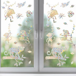 Detailed view of colorful monkey window stickers with rainbow prism effects on glass