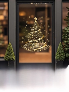 Detail of golden Christmas tree window sticker with stars and snowflake decals