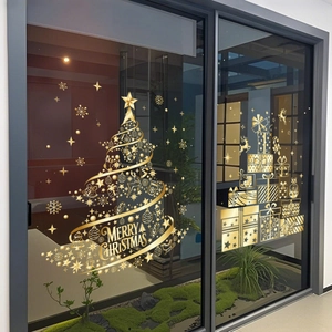 Detail view of golden Christmas tree and gift box static stickers on glass door