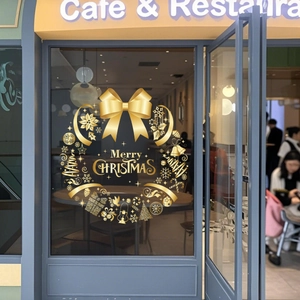 Golden Christmas wreath window sticker with Merry Christmas text on cafe glass door