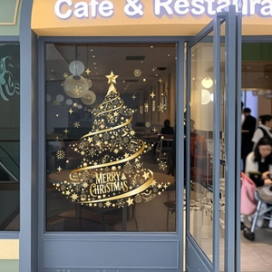 Golden Christmas tree window sticker with star and reindeer details on a glass door
