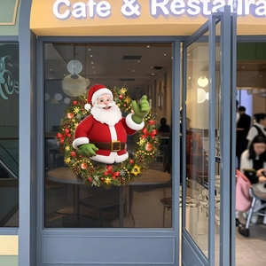 Dettaglio dell'adesivo natalizio con Babbo Natale su una porta di vetro