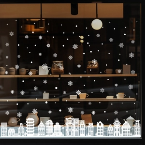 Detailed white snowflake and winter city silhouette stickers on a glass window