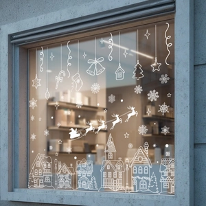 Close-up of white snowflake and European village decals on a festive shop window