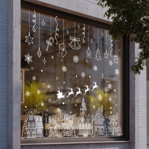 Detail of white Christmas window decals featuring snow houses and festive snowflakes
