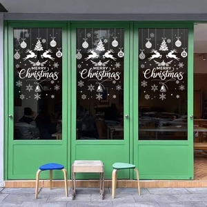 White Christmas window decals with reindeer and snowflakes on a green glass door