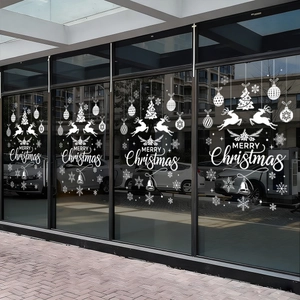 White Christmas window decals featuring elk and snowflakes on a store glass window