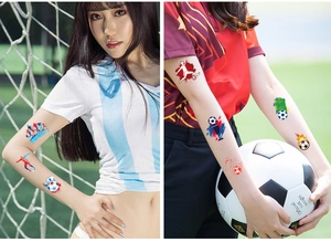 Close-up of waterproof football temporary tattoos on arm with soccer field background