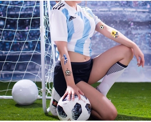 Kids football temporary tattoos showing soccer player silhouettes on skin outdoors