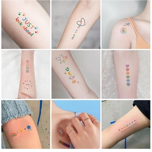 Detail showing colorful rainbow, heart, and smile temporary tattoo stickers on skin