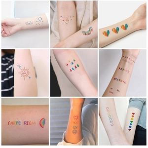 Detailed view of colorful rainbow and heart temporary tattoo stickers on arm skin