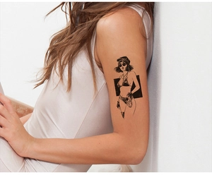 Dettaglio di un tatuaggio temporaneo retrò sul braccio di una modella stile dark chic