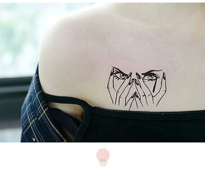 Dettaglio di un tatuaggio temporaneo nero minimalista con occhio e mano sulla pelle