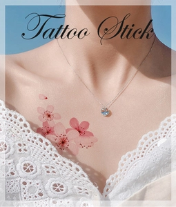 Detail of pink cherry blossom temporary tattoo applied on a woman's collarbone