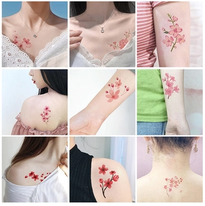 Detail showing various pink cherry blossom tattoo stickers applied to skin surfaces
