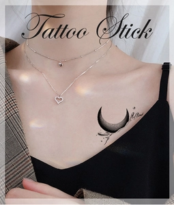 Minimalist black crescent moon temporary tattoo sticker applied to the collarbone area