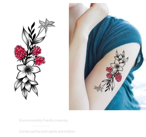 Detail of red berry and floral temporary tattoo stickers with realistic arm placement view