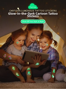 Luminous cartoon temporary tattoos on children's skin glowing in a dark indoor tent setting