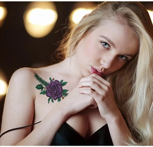 Detail of realistic purple rose tattoo sticker applied on model shoulder and collarbone