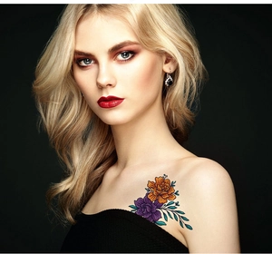 Colorful floral temporary tattoo on shoulder showing realistic orange and purple flowers