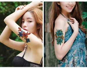Close-up of colorful floral tattoo stickers on arm with elegant lily and flower designs