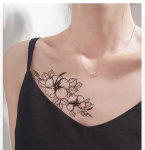 Detail of floral sketch tattoo sticker on neck with delicate black line hibiscus flower