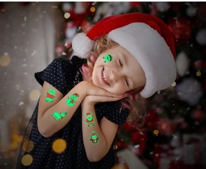 Tatouages temporaires de Noël fluorescents sur le bras d'un enfant en décor festif