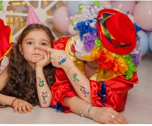 Close-up of colorful circus clown temporary tattoos for kids at a birthday party