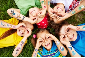 Colorful cartoon temporary tattoos for kids featuring animals and cars on grass background