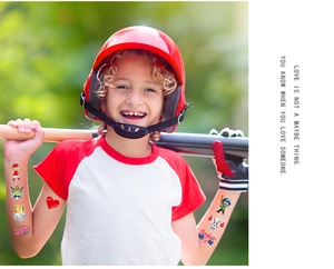 Outdoor shot of a boy with baseball temporary tattoos featuring cartoon players and gear