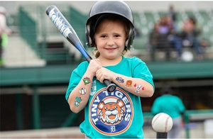 Gros plan détaillé de tatouages temporaires de baseball sur le bras d'un enfant en tenue de sport