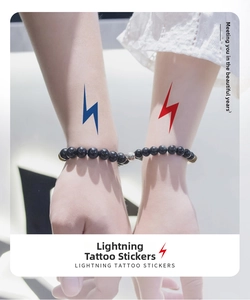 Wrist close-up of red and blue lightning temporary tattoos for couple styling