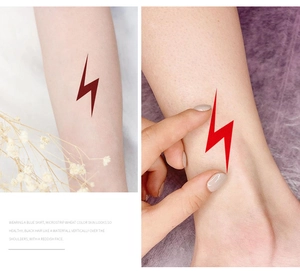 Macro detail of red lightning temporary tattoo stickers applied on arm with artistic layout