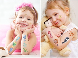 Vue détaillée de tatouages pailletés d'animaux marins sur le bras et le visage d'un enfant