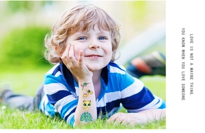 Outdoor shot of kids colorful glitter temporary tattoos featuring animals on arm